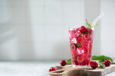 cocktail with cherry juice, mint, and ice in a glass, close-up, copy spaceの写真素材