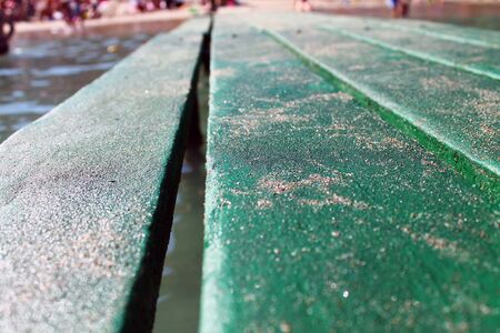 Green wood pier with sand on the seaの写真素材