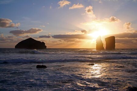 The sunset on the ocean with the stones