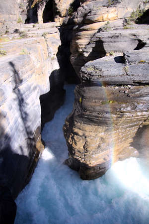 The river rapids and the rainbow colors in Mistaya Canyon in Banff National Park in Canadaの写真素材