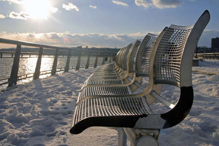 The metallic benches with the sunset in a cold winter scene in New York Cityの写真素材