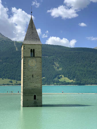 The bell tower of Curon in the italian Alpsの写真素材