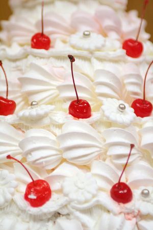 white whipped cream cake decorated with red cherryの写真素材
