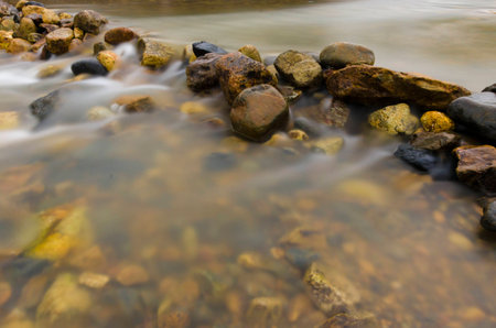 Nature landscape view of a running stream with rocksの写真素材