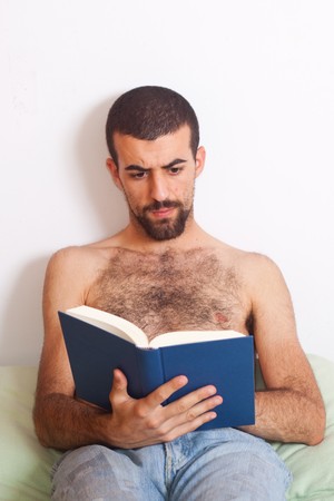 man reading a book on the bedの写真素材