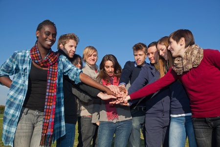 Happy College Students with Hands on Stack の写真素材