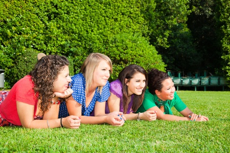 Teenage Female Friends Lying on Green at Parkの写真素材