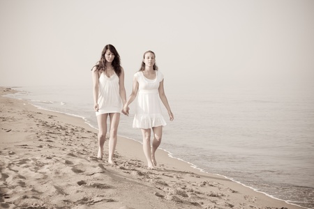 Female Friends Walking Together in the Seasideの写真素材