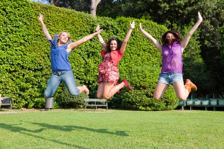 Happy Teenage Female Friends Jumpingの写真素材