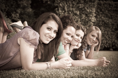 Teenage Female Friends Lying on Green at Parkの写真素材