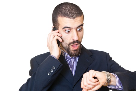Busy Businessman Talking on Mobile While Looking at Timeの写真素材