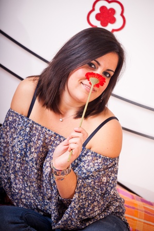 Woman Smelling a Flower on the Bedの写真素材