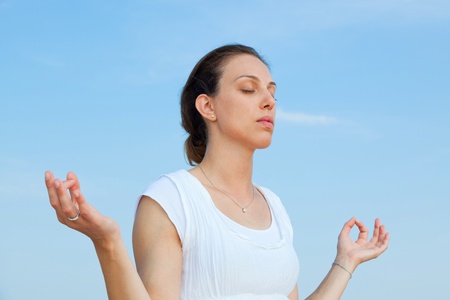 Beautiful Young Woman Doing Yoga Exercises at Seasideの写真素材