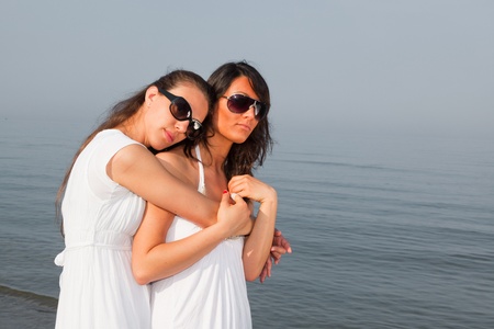 Two Female Friends Embraced on the Beachの写真素材