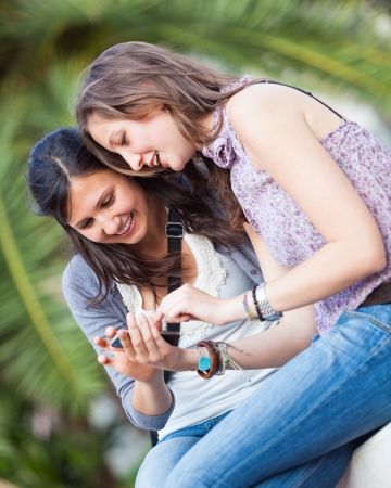 Two Beautiful Women Sending Messages with Mobileの写真素材
