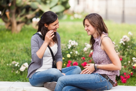 Two Young Women on a Bench at Parkの写真素材