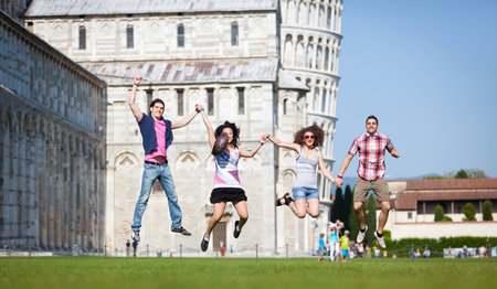 Group of Friends Jumping with Pisa Leaning Tower on Backgroundの写真素材