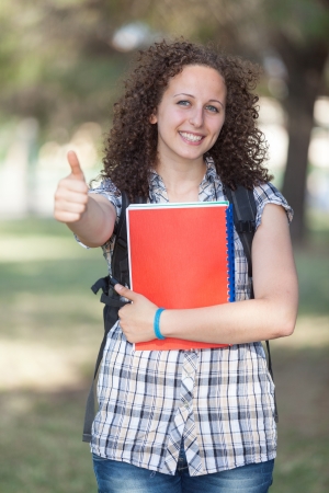 Young Beautiful Female Student with Thumb Upの写真素材