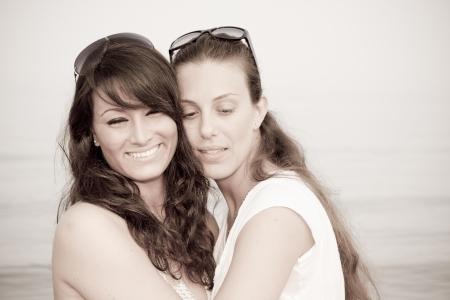 Two Female Friends Embraced on the Beachの写真素材