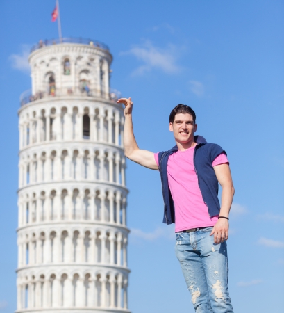 Young Man Posing with Leaning Tower in Pisaの写真素材