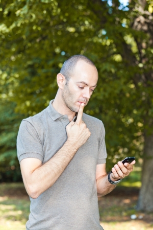 Man with Mobile Phone at Parkの写真素材