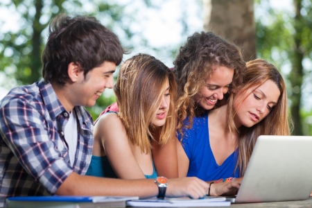 Group of Teenage Students at Park with Computer and Booksの写真素材