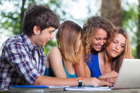 Group of Teenage Students at Park with Computer and Booksの写真素材