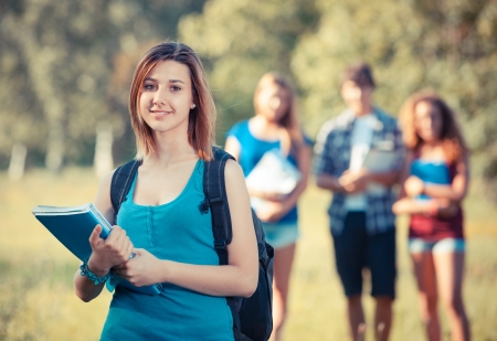Young Female Student at Park with Other Friendsの写真素材