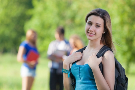 Young Female Student at Park with Other Friendsの写真素材