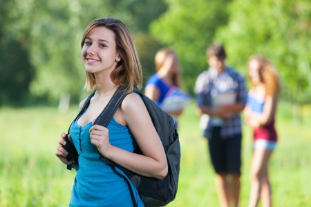 Young Female Student at Park with Other Friendsの写真素材