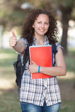 Young Beautiful Female Student with Thumb Upの写真素材