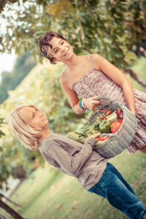 Boy and Girl Holding Basket of Vegetablesの写真素材