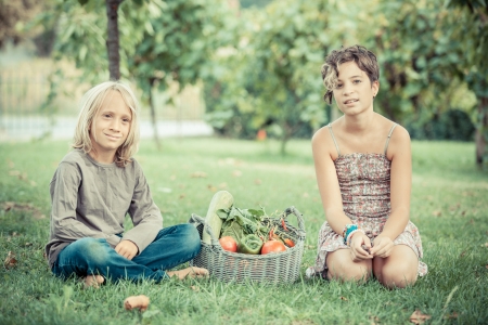 Boy and Girl Holding Basket of Vegetablesの写真素材