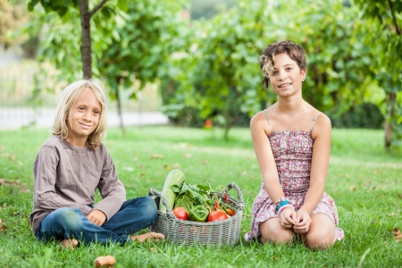 Boy and Girl Holding Basket of Vegetablesの写真素材