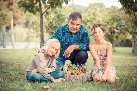 Adult Farmer with Children and Harvested Vegetablesの写真素材