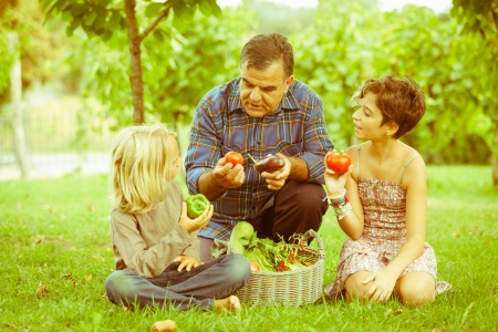 Adult Farmer with Children and Harvested Vegetablesの写真素材
