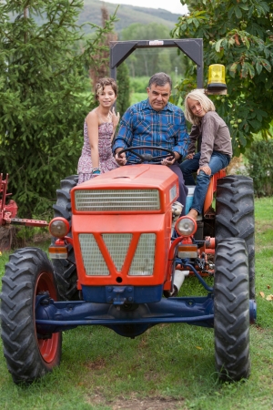 Adult Farmer with Children on Tractorの写真素材