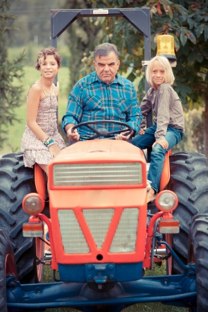 Adult Farmer with Children on Tractorの写真素材