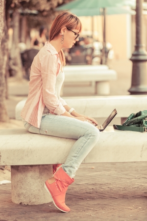 Beautiful Young Woman with Computer Outsideの写真素材