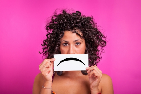Young Woman with Sad Emoticon on Fuchsia Backgroundの写真素材