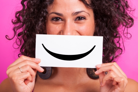 Young Woman with Smiley Emoticon on Fuchsia Backgroundの写真素材