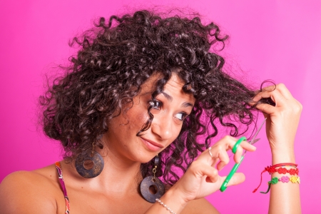 Young Woman Cutting her Curly Hairsの写真素材