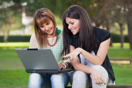Two Young Women with Computer at Parkの写真素材