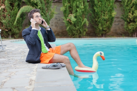 Funny Young Businessman with SwimmingTrunks next to the Poolの写真素材