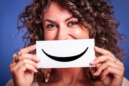 Young Woman with Smiley Emoticon on Blue Backgroundの写真素材