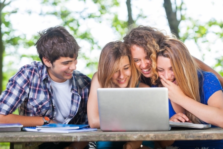 Group of Teenage Students at Park with Computer and Booksの写真素材