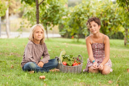 Boy and Girl Holding Basket of Vegetablesの写真素材