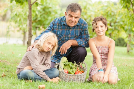 Adult Farmer with Children and Harvested Vegetablesの写真素材