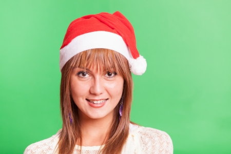 Cheerful Woman with Santa Hat on Green Backgroundの写真素材