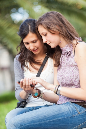 Two Beautiful Women Sending Messages with Mobileの写真素材